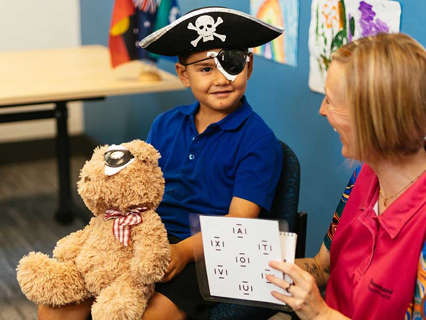 A nurse conducts a vision screening assessment on a prep student.