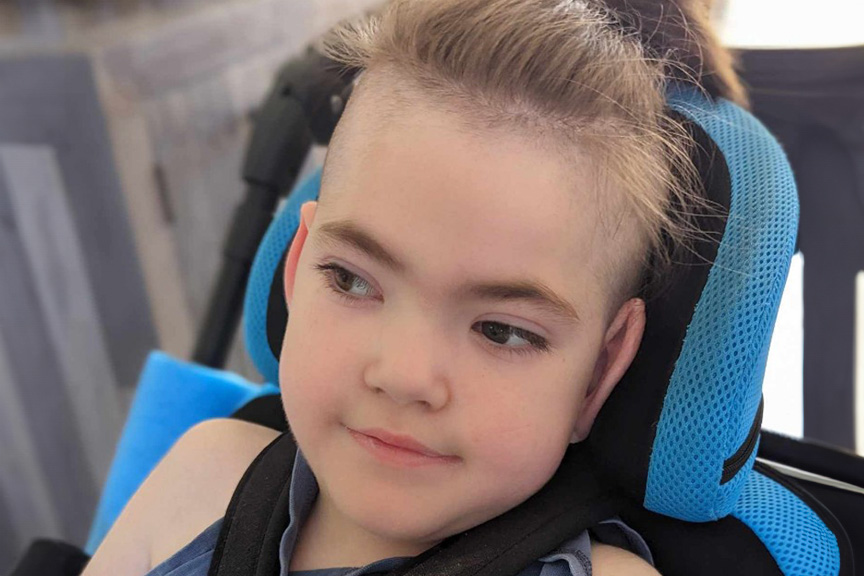 Ricky aged 5 smiling in his wheelchair