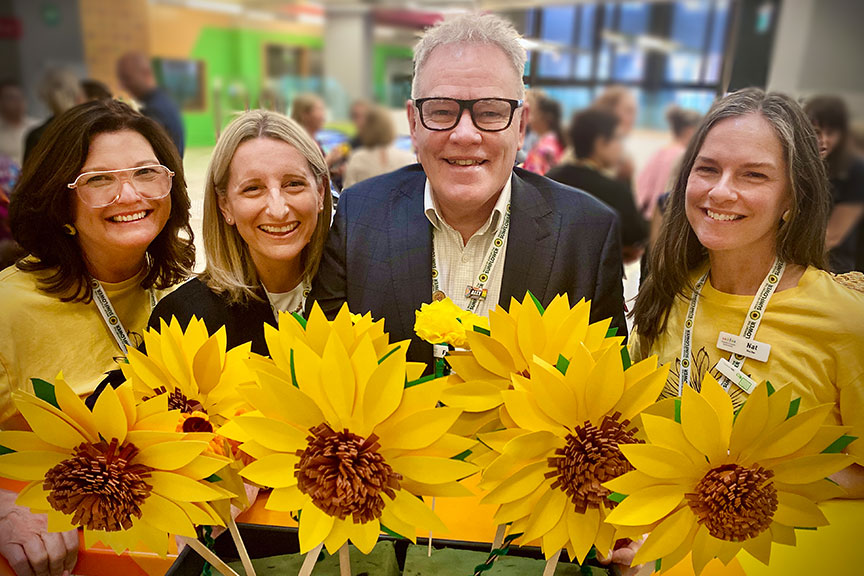 4 people holding sunflowers