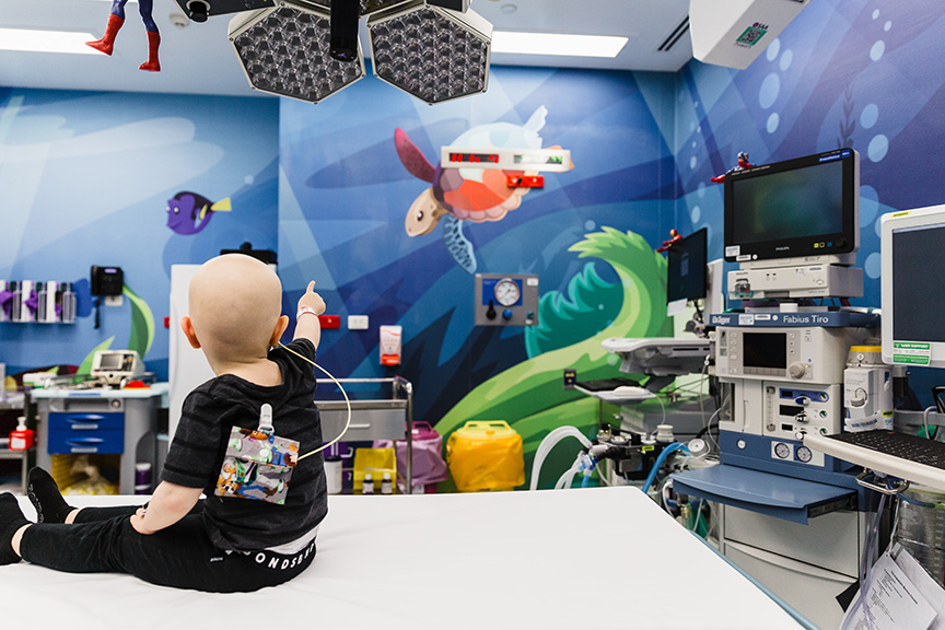 Child on a hospital bed looking at a screen. 
